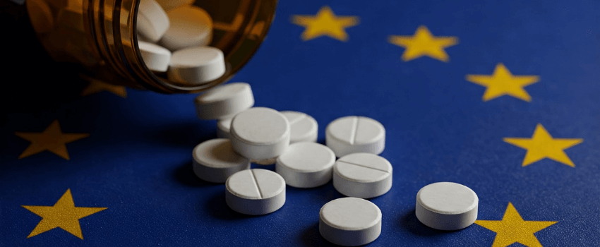 Pills spilling out on to European Union Flag from a bottle.
